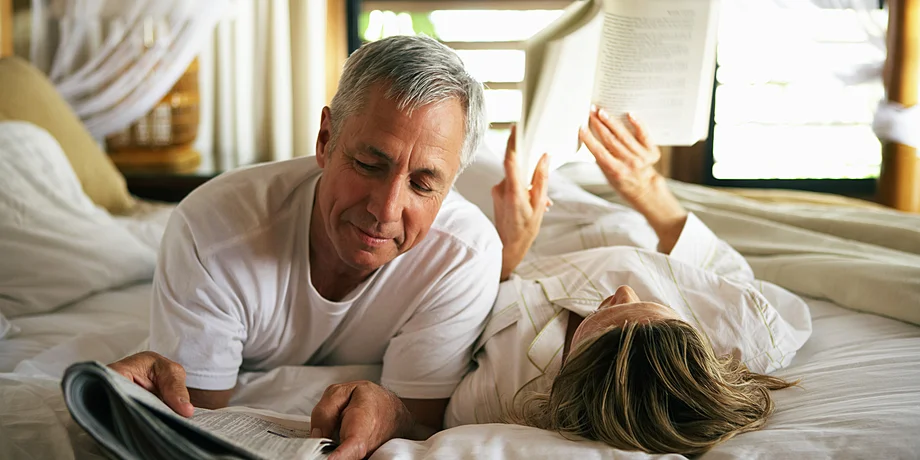 Couple laying in bed reading