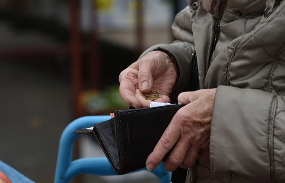 Man holding a coin while opening a wallet